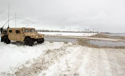 Spc. Keith J. Pic, of Fargo, and Airman 1st Class Paul W. Bartron, of West Fargo, wait in their Humvee at a major intersection while staffing a traffic control point in downtown Fargo.