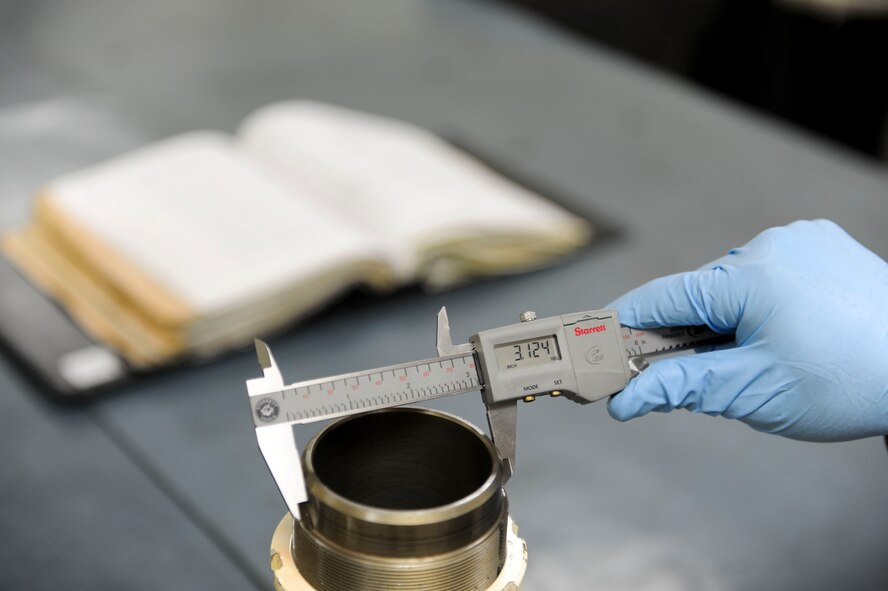 U.S. Air Force Airman 1st Class Christopher Beltran, 18th Component Maintenance Squadron hydraulics apprentice, checks the diameter of an F-15 Eagle aircraft cylinder barrel with a digital micrometer on Kadena Air Base, Japan, Aug. 6, 2013. The 18th CMS is responsible for test measurement and diagnostic equipment services to the wing and associate units, as well as maintenance services essential to daily aircraft sortie production and unit deployments. (U.S. Air Force photo by Airman 1st Class Justin Veazie/Released)