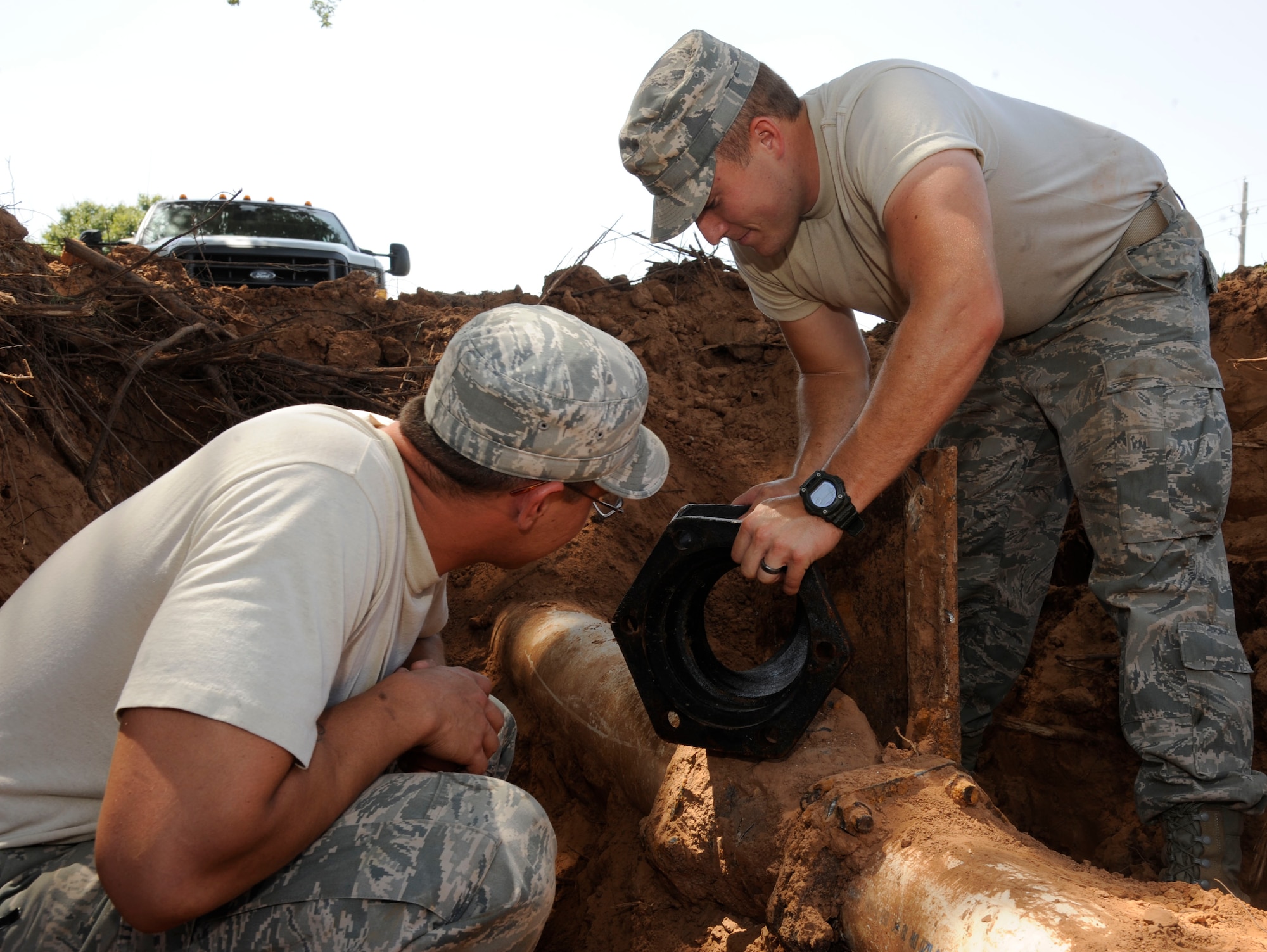 Senior Airman Michael Bustamante, left, and Airman 1st Class Jefferson Bowler, both from the 2nd Civil Engineer Squadron Water and Fuels Systems Maintenance, determine where to place a 45 degree mechanical joint on Barksdale Air Force Base, La., Aug. 7, 2013. The joint was used to shift the direction of piping during the installation of a fire hydrant. (U.S. Air Force photo/Airman 1st Class Andrew Moua)