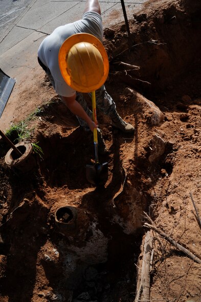 Airman 1st Class Jefferson Bowler, 2nd Civil Engineer Squadron Water and Fuels Systems Maintenance journeyman, digs to expose concrete for removal on Barksdale Air Force Base, La., Aug. 7, 2013. Bowler needed to determine how much concrete was underground and remove it in order to install a fire hydrant. (U.S. Air Force photo/Airman 1st Class Andrew Moua)