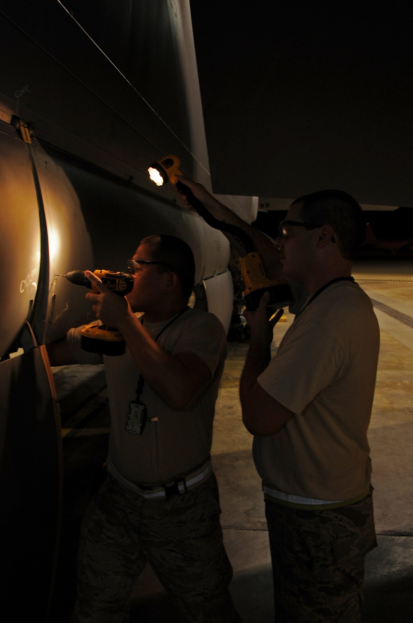 Staff Sgt Steven Gutierrez and Staff Sgt. John Clark, both from the 2nd Maintenance Squadron sheetmetal, drill a cracked panel on the bomb bay door of a B-52H Stratofortress at Barksdale Air Force Base, La., Aug. 5, 2013. The 2nd MXS sheetmetal shop are one of many flightline maintenance shops that have night shifts to support the flying mission of Barksdale. (U.S. Air Force photo/Staff Sgt. Jason McCasland)