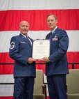 Maj. Jeff Gorman, 934th Aircraft Maintenance Squadron commander, presents Senior Master Sgt. James Orze with his certificate of retirement during the August Unit Training Assembly weekend at Minneapolis-St. Paul Air Reserve Station, Minn.  (U.S. Air Force photo/SrA Trevor Saylor)