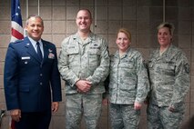 Col. Todd McCubbin, 934th Airlift Wing vice commander, presents Senior Master Sgt. Todd Liffin, Master Sgts. Anna Bartlett, and Jodi Knight with commander's coins in recognition of their efforts during the Wing's Operational Readiness Exercise.  (U.S. Air Force photo/Tech. Sgt. Kimberly Hickey)