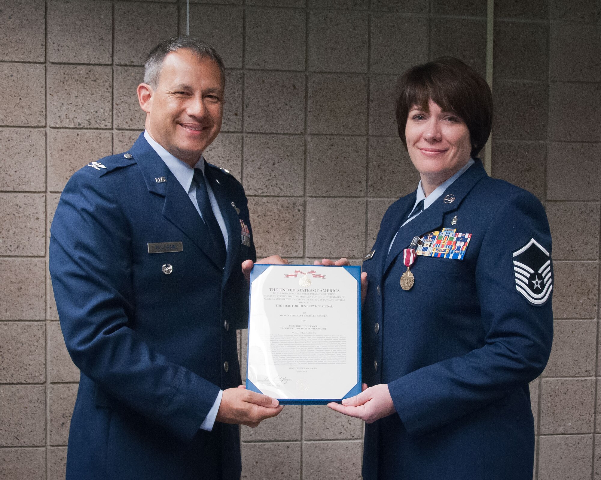 Col. Todd McCubbin, 934th Airlift Wing vice commander, presents Master Sgt. Danielle Romero, 934th Airlift Wing Combat Readiness, with her Meritorious Service Medal during the August Unit Training Assembly weekend.  (U.S. Air Force photo/Tech. Sgt. Kimberly Hickey)