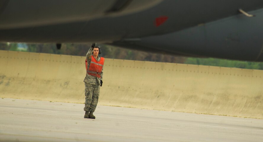 A crew chief assigned to the 5th Aircraft Maintenance Squadron gives a thumbs-up to the aircrew as a B-52H Stratofortress taxis by. Crew chiefs are responsible for ensuring the aircraft is in perfect working condition. They also perform scheduled inspections and preventive maintenance on B-52s and the equipment installed inside the aircraft. (U.S. Air Force photo/Senior Airman Brittany Y. Auld)