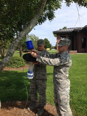 Senior Airman Kelby Rosengarten and Airman First Class Jake Palmer, 628th Aerospace Medicine Squadron Public Health technicians, hang traps to capture mosquitoes for identification at Joint Base Charleston – Air Base. (Courtesy photo)