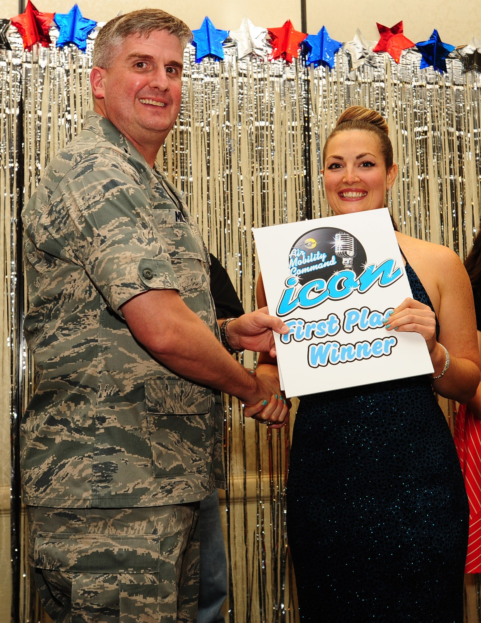 Col. Albert Miller, 437th Airlift Wing vice commander, awards Eryn Pope, 628th Force Support Squadron Single Airman Initiative coordinator, first place during the Air Mobility Command Icon Talent Contest Aug. 1, 2013, at Joint Base Charleston - Air Base, S.C. Pope from Oklahoma City, Okla., performed  Adele’s “Someone Like You.” (U.S. Air Force photo/ Airman 1st Class Chacarra Neal)