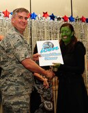 Col. Albert Miller, 437th Airlift Wing vice commander, awards Airman 1st Class Sydney Manning, 1st Combat Camera Squadron videographer, second place during the Air Mobility Command Icon Talent Contest Aug. 1, 2013, at Joint Base Charleston - Air Base, S.C. The AMC Icon program is loosely based on the hit TV program, “American Idol.” Manning, from Nampa, Idaho, performed Idina Menzel’s “The Wizard and I.” (U.S. Air Force photo/ Airman 1st Class Chacarra Neal)