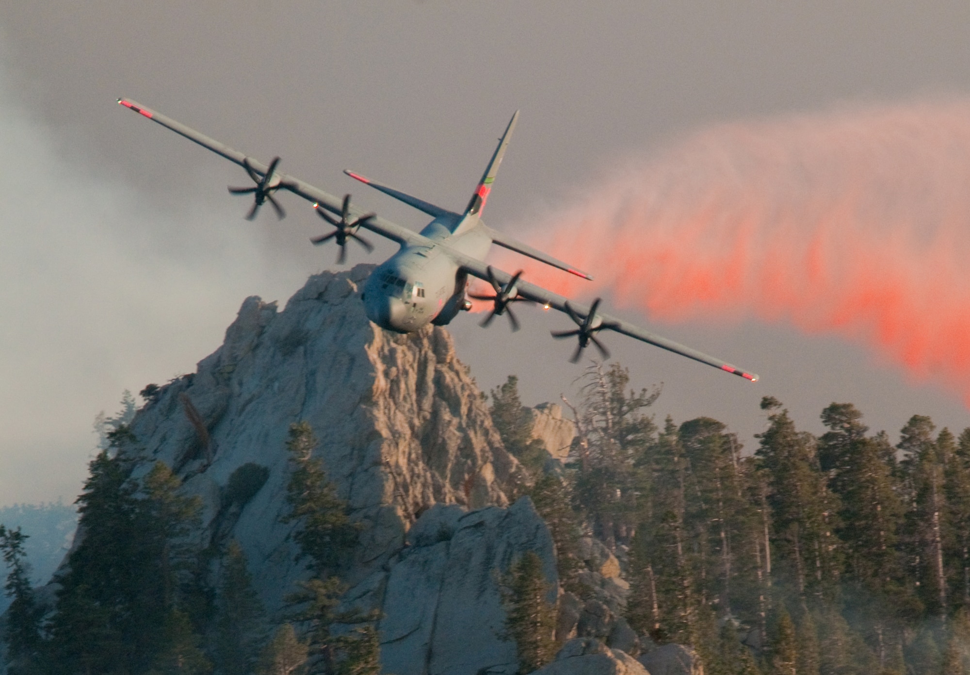 MAFFS 6, a C130J from the 146th Airlift Wing in Port Hueneme, Calif., drops a line of retardant over the trees in the mountains above Palm Springs July 19, 2013. (Air National Guard photo by: Senior Airman Nicholas Carzis.)
