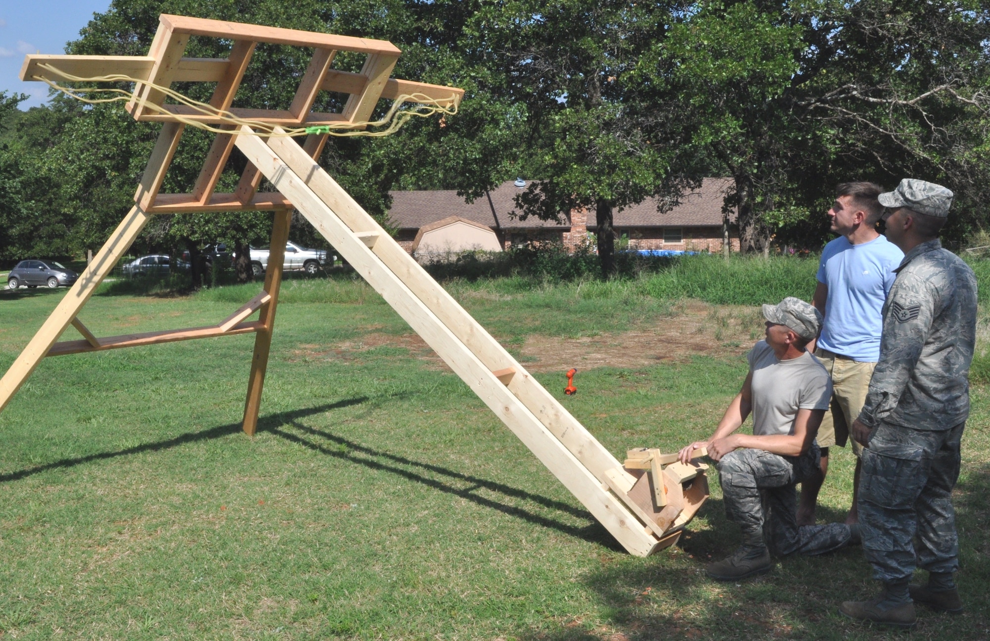 Master Sgt. Patrick Patterson cocks the catapult he and two other NCOs from the 960th AACS intend to enter in “Viking Fest” this fall. Their machine was constructed from 2x6s and uses three 100-pound exercise bands as its power source. “Considering its mobility, along with the ability to change the launch angle and to fine-tune the tension, we can put ‘warheads on foreheads’ anywhere on the field,” said Patterson, the principal designer of the medieval siege engine. (Air Force photos by Mike W. Ray)
