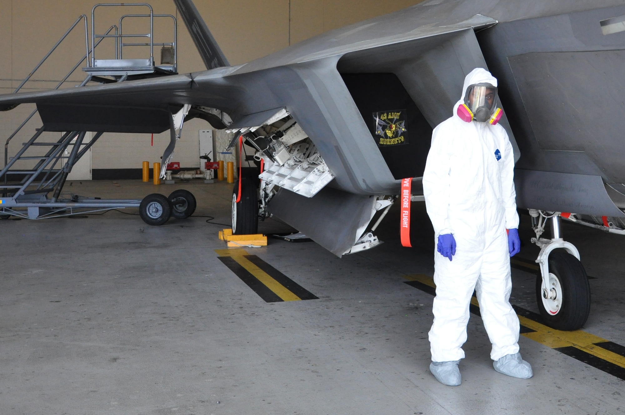 Airman 1st Class Freddie Newman, 325th MXS Low Observable apprentice poses next to an F-22 Raptor Aug. 1 at Tyndall Air Force Base. The 325th Maintenance Squadron Low Observable makes sure the F-22 s at Tyndall maintain their stealth capabilities by restoring and maintaining the Low Observable coatings on the aircraft. (U.S. Air Force photo by Airman 1st Class Alex Echols)