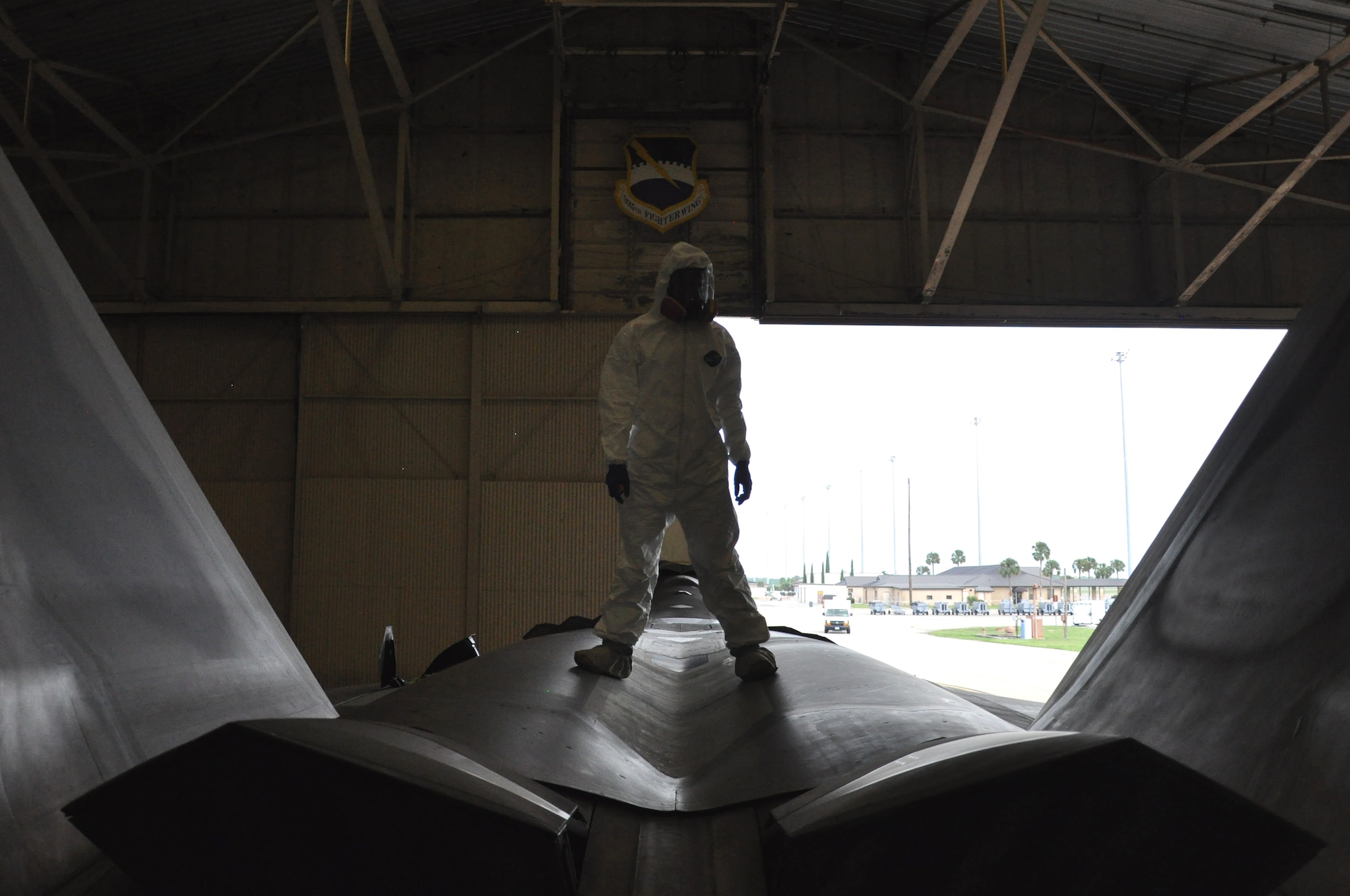 Airman 1st Class Freddie Newman, 325th MXS Low Observable apprentice, poses on top of an F-22 Raptor Aug. 1 at Tyndall Air Force Base. The 325th Maintenance Squadron Low Observable makes sure the F-22 s at Tyndall maintain their stealth capabilities by restoring and maintaining the Low Observable coatings on the aircraft. (U.S. Air Force photo by Airman 1st Class Alex Echols)