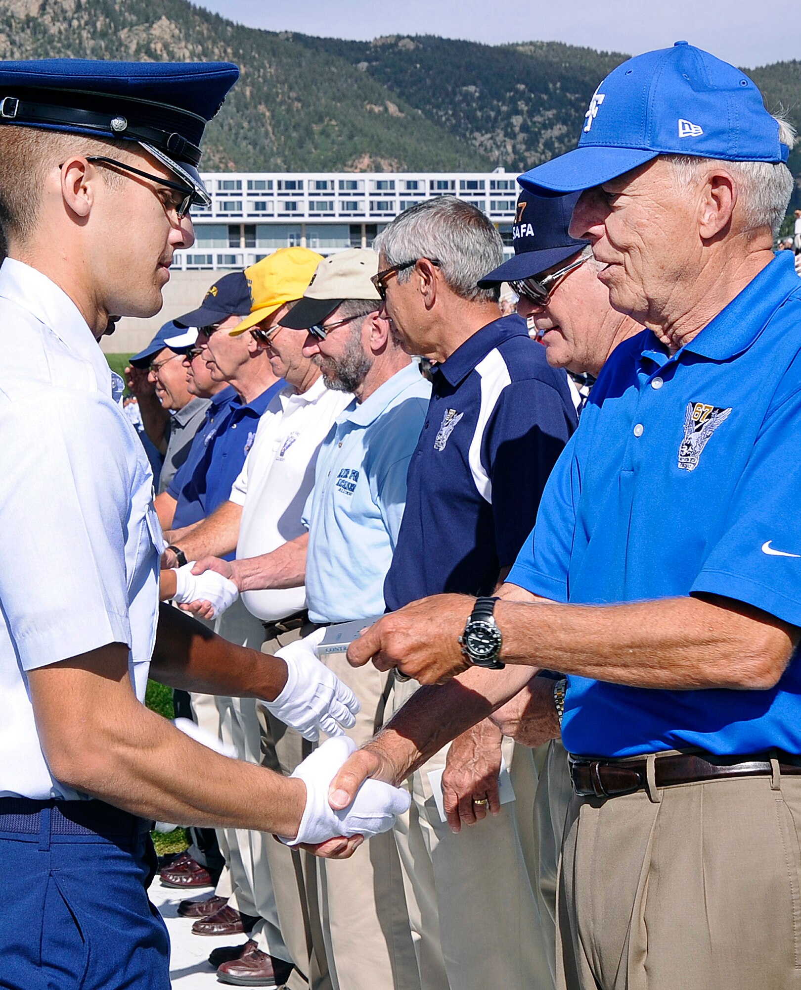 Cadet 4th Class Eric Zielen-Ersing accepts a copy of Contrails from retired Brig. Gen. Richard Carleton during the Class of 2017 Acceptance Parade at the Air Force Academy Aug. 6, 2013. Zielen-Ersing was one of eight outstanding basic cadets named at the end of Basic Cadet Training. Carleton is an alumnus with the Class of 1967, which is the legacy class for the incoming freshmen. (U.S. Air Force photo/Sarah Chambers)