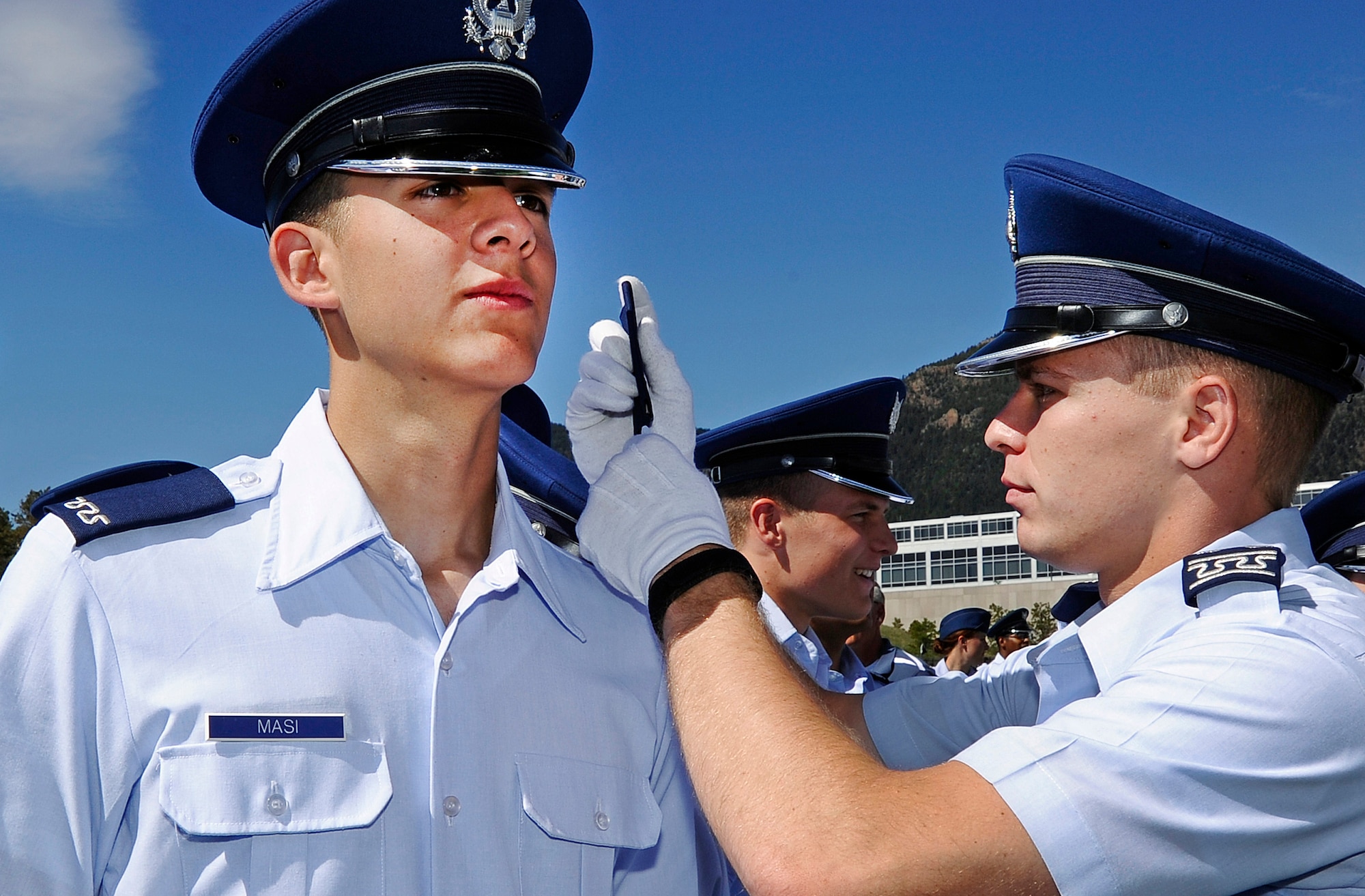 Cadet 1st Class Samuel Byrne, right, places epaulets on the shoulders of Cadet 4th Class Christopher Masi after the Air Force Academy's Acceptance Day parade Aug. 6, 2013. Byrne and Masi are assigned to Cadet Squadron 14. (U.S. Air Force photo/Sarah Chambers)