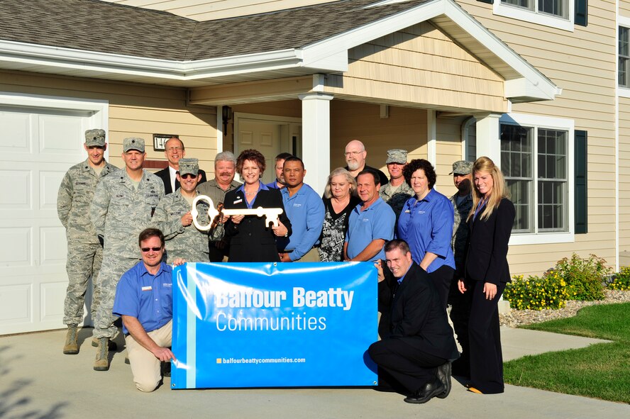 Col. William Mazzeno, 5th Mission Support Group commander, passes a “key” to Tana Waldren, Community Manager for Balfour Beatty Communities, signifying the organization’s assumption of operations of Minot Family Housing, Aug. 1. Minot Air Force Base partnered with BBC under the Privatization of Family Housing Program as a way to provide quality, affordable housing, more efficiently than traditional processes allowed. (U.S. Air Force photo/Airman 1st Class Kristoffer Kaubisch) 