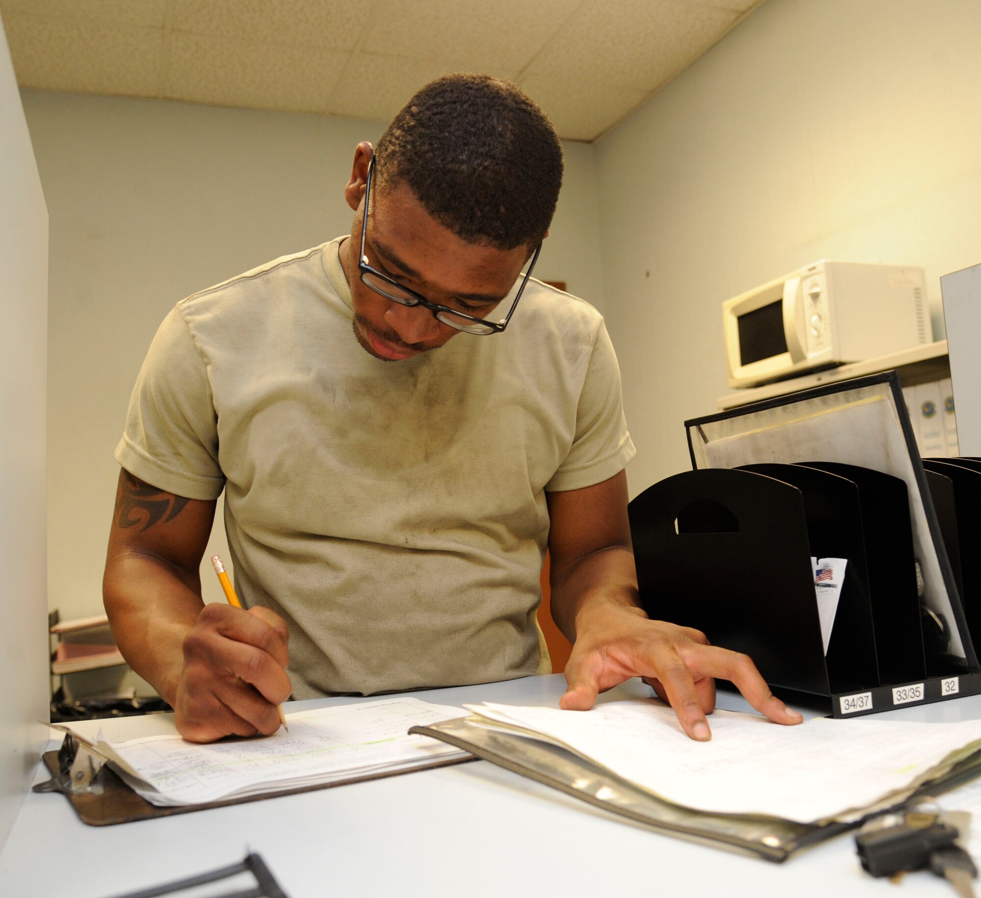 Airman 1st Class Jamil Dixon, 2nd Logistics Readiness Squadron vehicle maintenance journeyman, fills out a workorder on Barksdale Air Force Base, La., Aug. 6, 2013. Workorders are used to keep track of vehicles that need maintenance and for maintenance records. (U.S. Air Force photo/Airman 1st Class Andrew Moua)