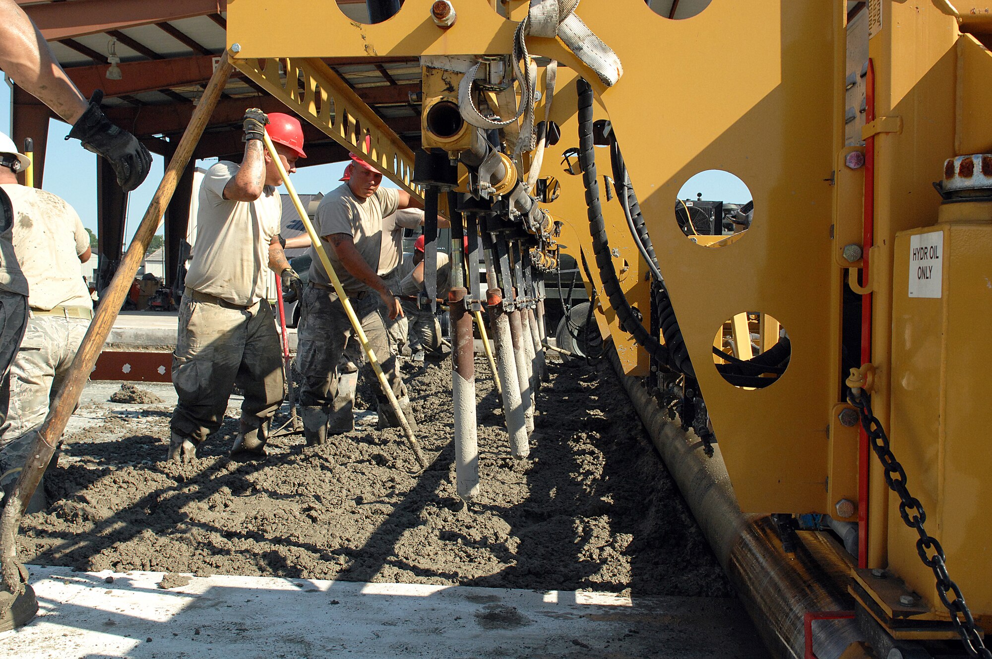 U.S. Air Force Airmen assigned to the 823rd Rapid Engineer Deployable Heavy Operational Repair Squadron Engineers shovel concrete during a TDY at Seymour Johnson Air Force Base, N.C., July 26, 2013.  The crew repaired pavement at the F-15E Strike Eagle wash rack.  (U.S. Air Force photo by Airman 1st Class Brittain Crolley)
