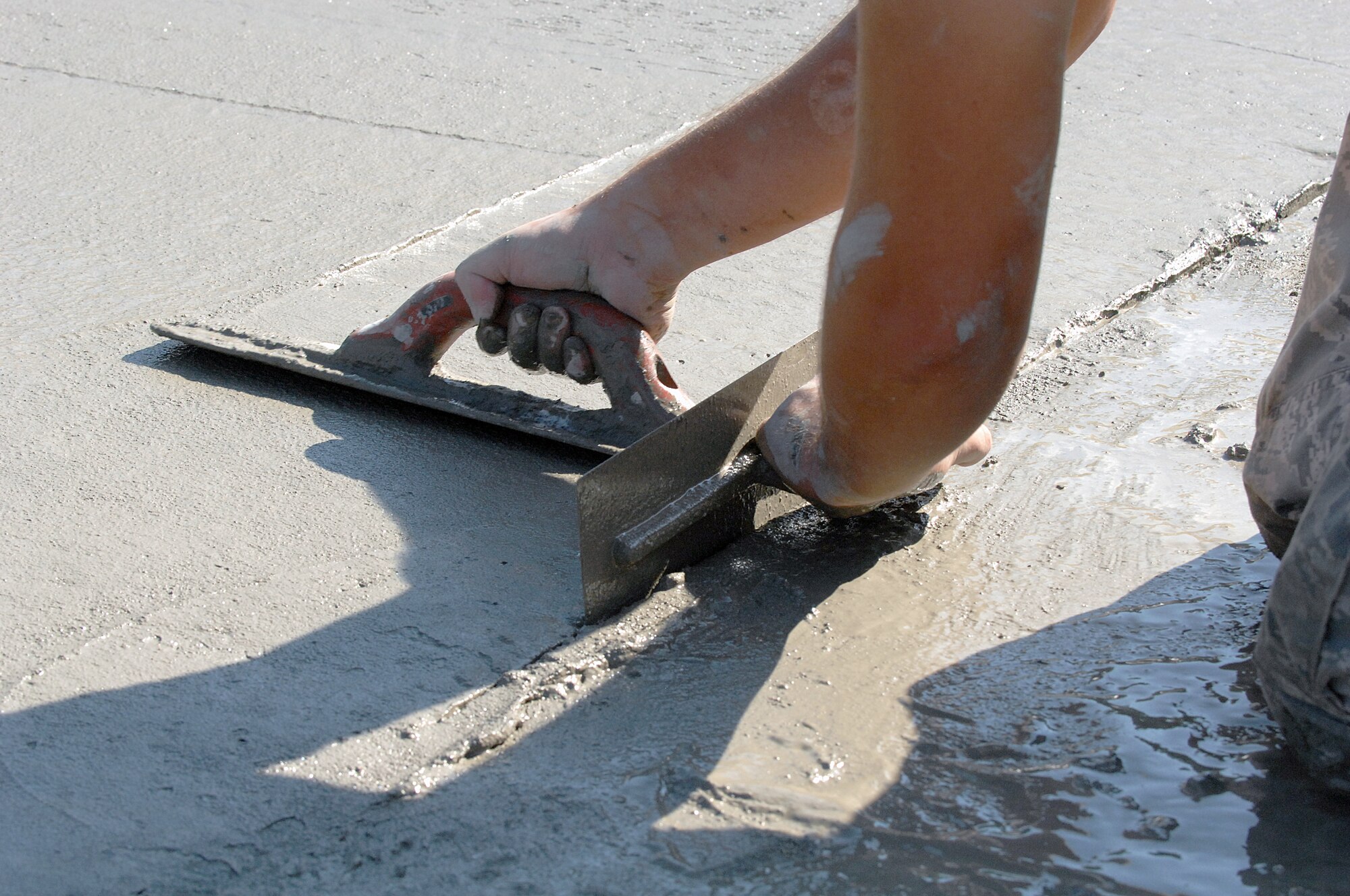 An Airman assigned to the 823rd Rapid Engineer Deployable Heavy Operational Repair Squadron Engineers smoothes and edges concrete during a training TDY at Seymour Johnson Air Force Base, N.C., July 26, 2013.  The training lasted about 60 days and was designed to test the unit’s capabilities and readiness. (U.S. Air Force photo by Airman 1st Class Brittain Crolley)