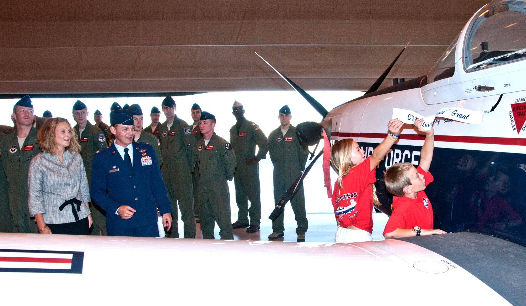 The new 8th Flying Training Squadron commander, Lt. Col. Troy Henderson and his wife, Sueanna, watch their son and daughter unveil the command aircraft after the change of command ceremony June 21 at Vance Air Force Base, Okla. (U.S. Air Force photo/ Terry Wasson)