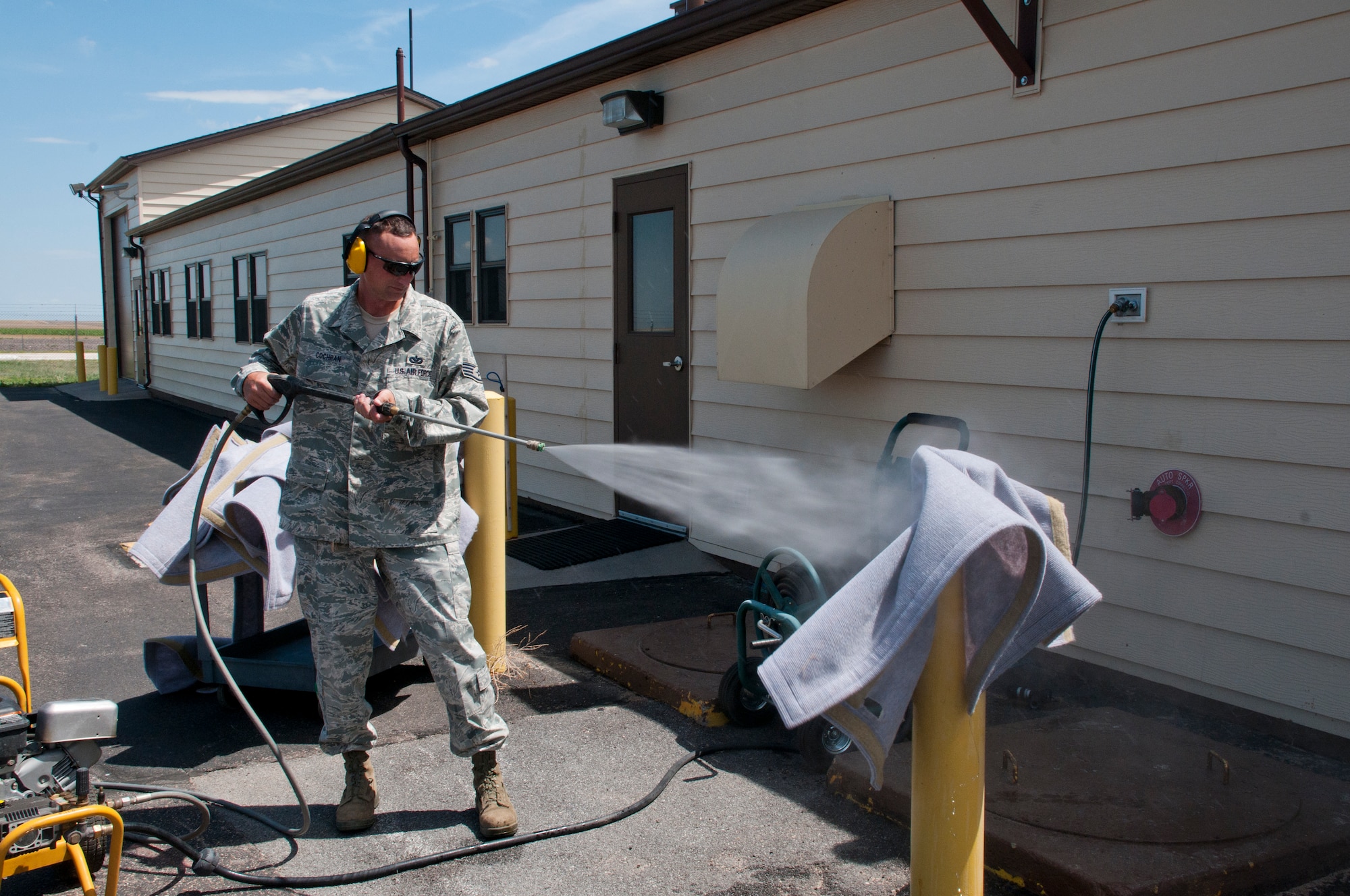 Staff Sgt. Clifford Cochran, 321st Missile Squadron facility manager, pressure washes one of the carpets lining the ceilings of a missile alert facility launch control center Aug. 2, 2013. (U.S. Air Force photo by Airman 1st Class Jason Wiese)