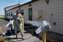Staff Sgt. Clifford Cochran, 321st Missile Squadron facility manager, pressure washes one of the carpets lining the ceilings of a missile alert facility launch control center Aug. 2, 2013. (U.S. Air Force photo by Airman 1st Class Jason Wiese)