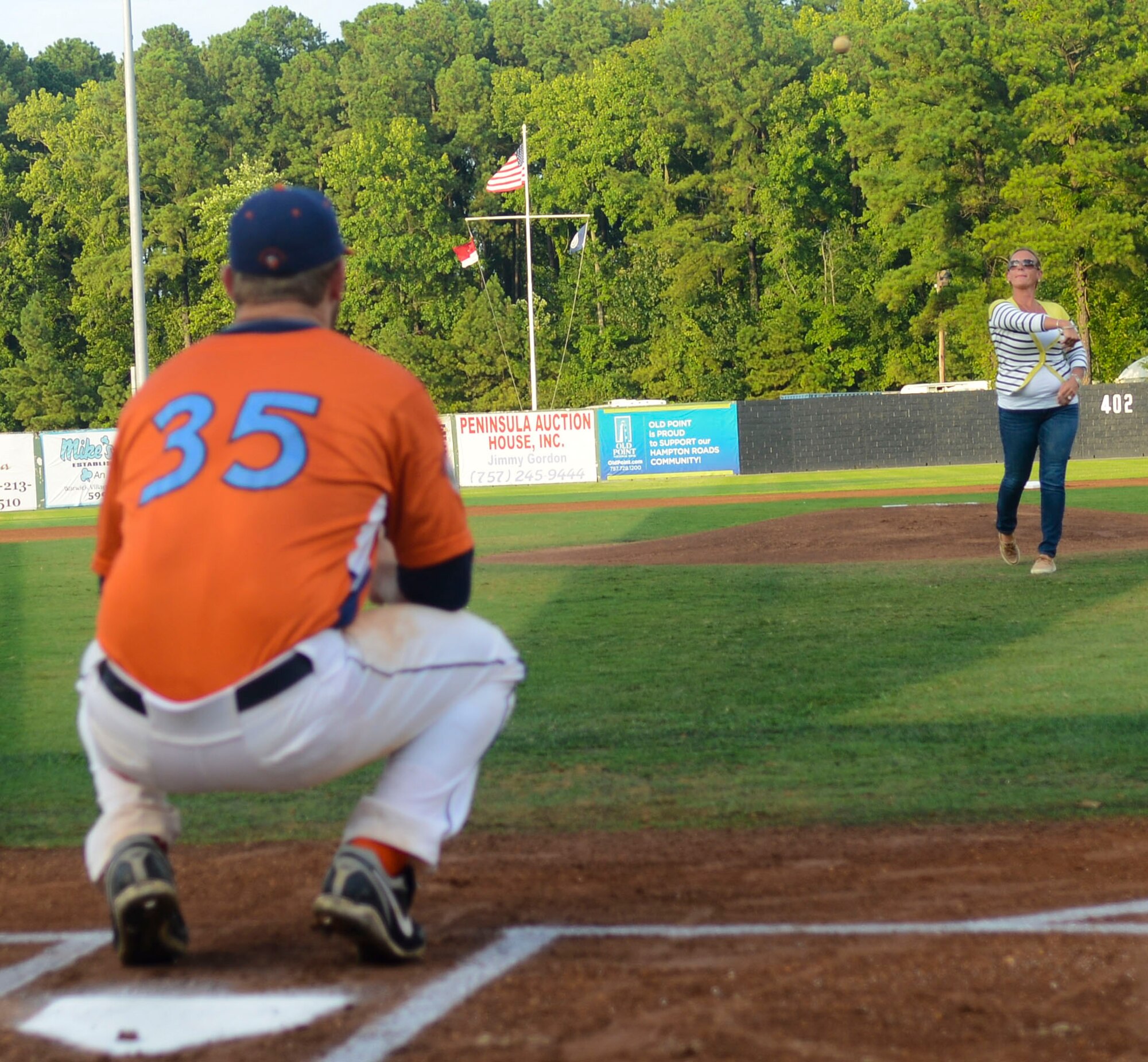 Melissa McDougall, a Gold Star family member, throws the first pitch at a Peninsula Pilots baseball game, Aug. 3, 2013, in Hampton, Va. The pictures of the Gold Star families’ fallen heroes were displayed in the 7th inning of the game. (U.S. Air Force photo by Airman 1st Class Austin Harvill/Released)
