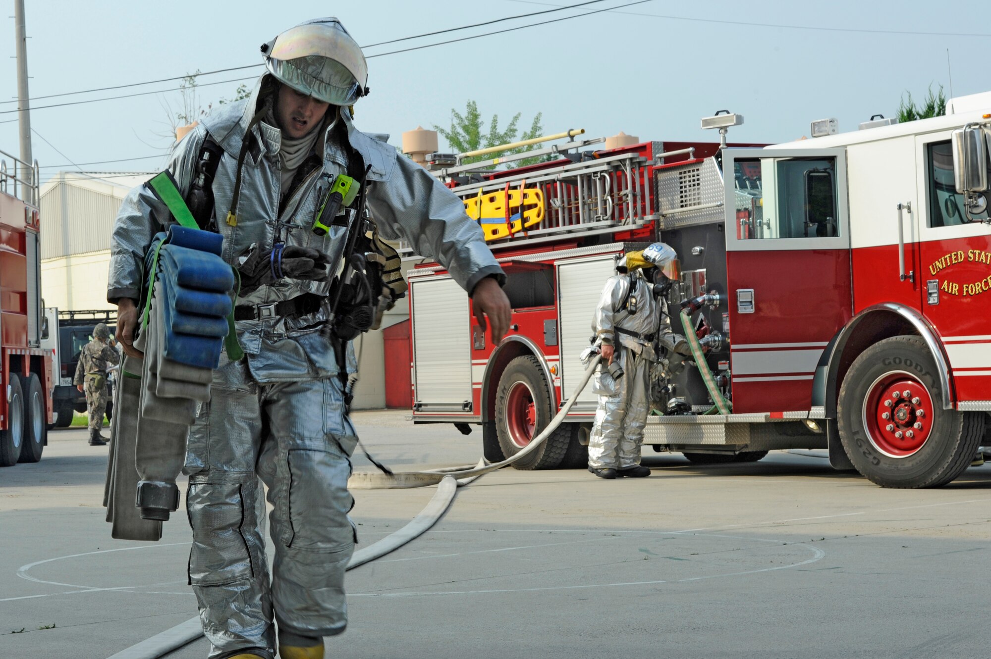 KUNSAN AIR BASE, Republic of Korea – Staff Sgt. Bryan Bereza, 8th Civil Engineer Squadron firefighter, hauls a fire hose to combat a simulated fire during exercise Beverly Midnight 13-3, Aug. 7, 2013. Republic of Korea air force and U.S. Air Force Airmen combined training scenarios to test the readiness of Kunsan personnel. (U.S. Air Force Photo by Staff Sgt. Tong Duong/Released)