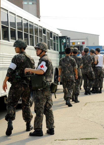KUNSAN AIR BASE, Republic of Korea – Medical staff from both the 8th Fighter Wing and the 38th Fighter Group assist the ‘injured’ onto a bus during exercise Beverly Midnight 13-3, Aug. 7, 2013. The exercise presented firefighters and medical staff with more than 30 casualties to assist and transport. (U.S. Air Force photo by Staff Sgt. Jessica Haas/Released)