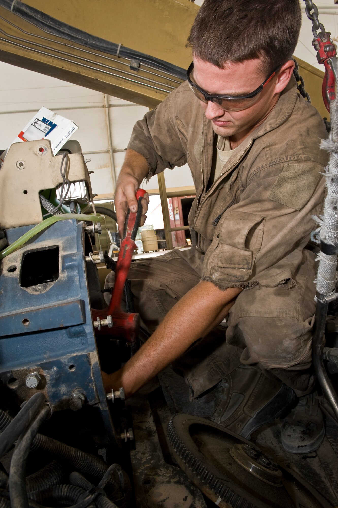 Airman 1st Class Tyler Jones performs routine maintenance on an aircraft cargo loader at the 379th Air Expeditionary Wing in Southwest Asia, July 31, 2013. Jones is a 379th Expeditionary Logistics Readiness Squadron vehicle mechanic deployed from Eielson Air Force Base, Alaska. (U.S. Air Force photo/Senior Airman Benjamin Stratton)