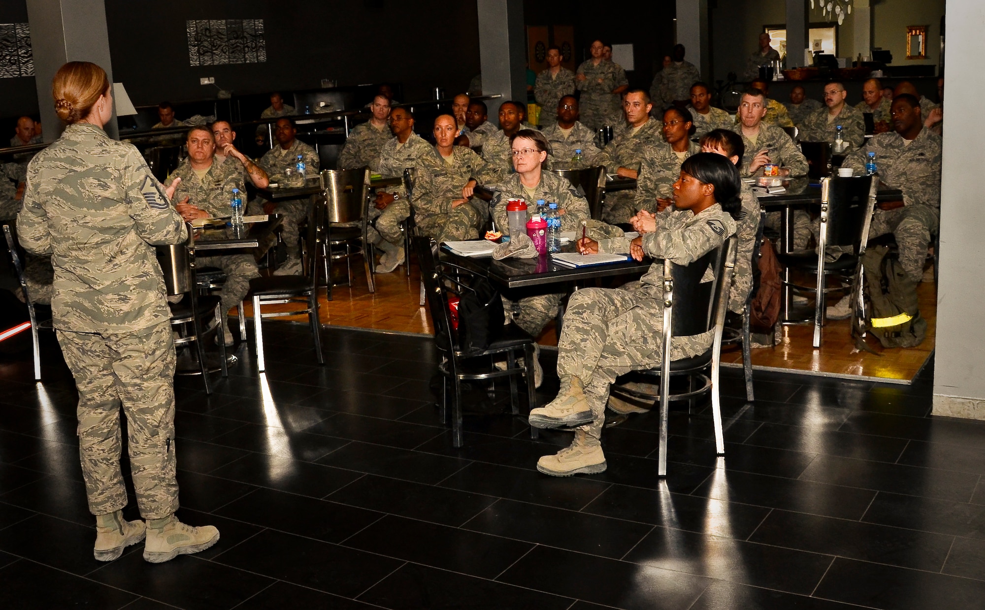 Grand Slam Airmen watch an Article 15 process video with discussions lead by Master Sgt. Melissa Somers during a First Sergeant Symposium at the 379th Air Expeditionary Wing in Southwest Asia, Aug. 8, 2013. The two-day course was designed to provide information and tools to aspiring first sergeants. Somers is the 379th Expeditionary Civil Engineer Squadron first sergeant deployed from Fairchild Air Force Base, Wash., and a course instructor. (U.S. Air Force photo/Senior Airman Benjamin Stratton)