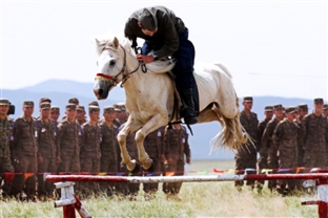 A Mongolian soldier jumps his horse during the opening ceremony for Khaan Quest 2013 at the Five Hills Training Area in Mongolia, Aug. 3, 2013. The United States and Mongolia sponsor the annual exercise, which is designed to strengthen the capabilities of U.S., Mongolian and other forces in international peace support operations.