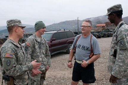 Spc. Thomas D. Hamilton spends time with Soldiers while they wait for the Thanksgiving meal to be served in northern Kosovo. Hamilton is serving his last holiday season in the Army National Guard before retiring in September 2013.