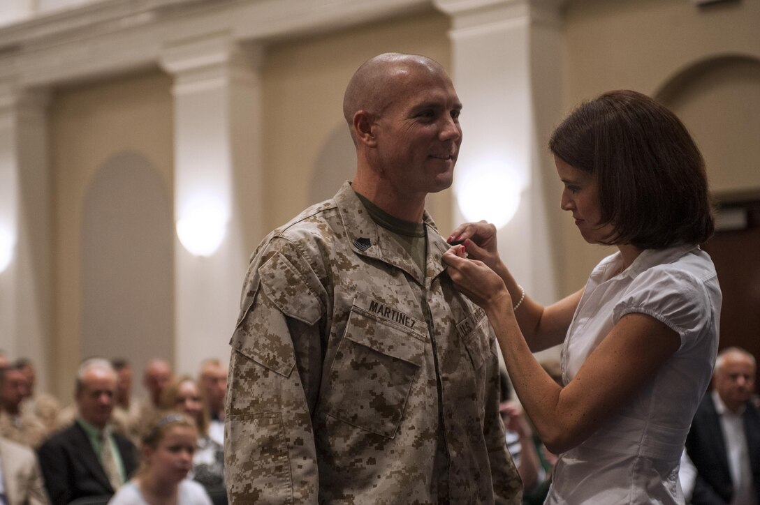 Master Sgt. Keith Martinez, U.S. Marine Drum & Bugle Corps assistant drum major, gets pinned with master sergeant chevrons by his wife during his promotion ceremony at Marine Barracks Washington, D.C., Aug. 1.