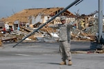 Pvt. First Class Jesus Ramos, 1139th Military Police Co., Missouri Army National Guard, directs traffic at a storm-damaged intersection after the tornado that killed more than 116 people.
