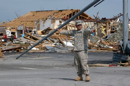 Pvt. First Class Jesus Ramos, 1139th Military Police Co., Missouri Army National Guard, directs traffic at a storm-damaged intersection after the tornado that killed more than 116 people.