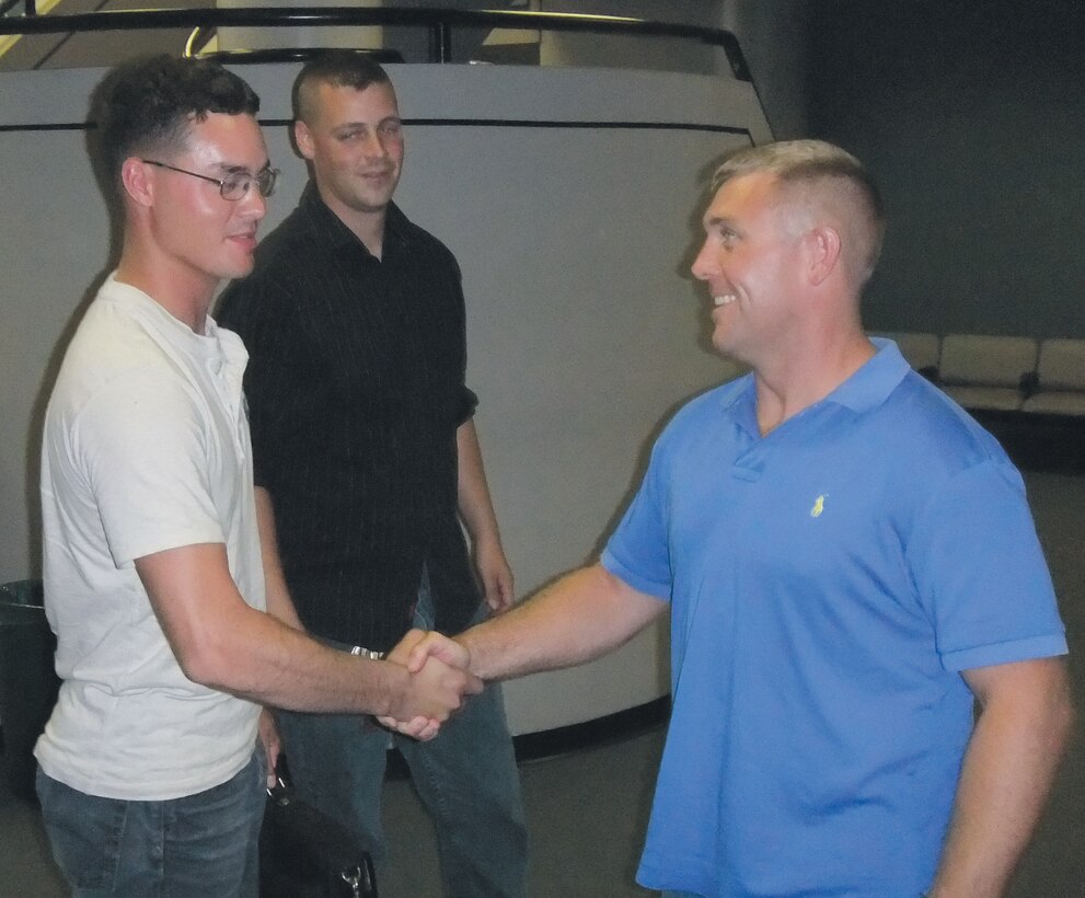 Sgt. Ronny Adams, left, noncommissioned officer-in-charge of the Warrior Express Service Team, Combat Logistics Regiment-2, receives a handshake from a Marine welcoming him home after a six-month deployment to Afghanistan.