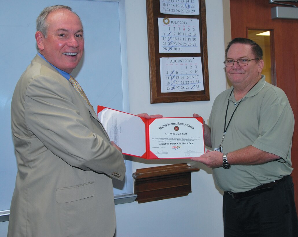 William J. Cuff, right, continuous process improvement specialist, Operations Division, Marine Depot Maintenance Command, receives a certificate from Michael T. Madden, executive deputy, Marine Corps Logistics Command, for being the first Lean Six Sigma black belt in MDMC, recently.