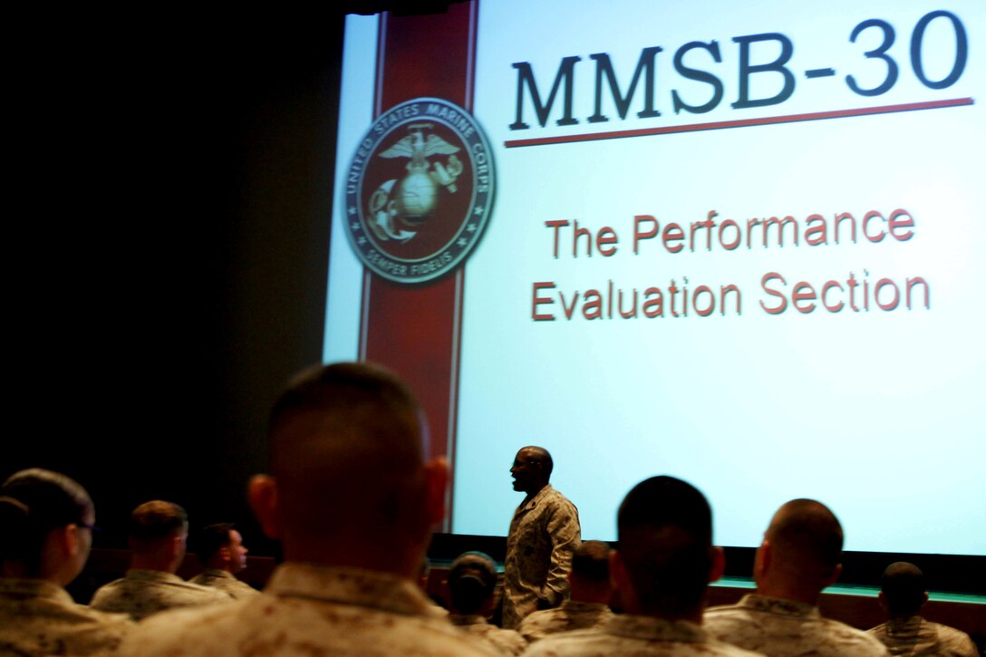 Sgt. Maj. Mark A. Byrd introduces himself before beginning the Manpower Management Support Branch Promotion and Performance brief at the base theater here Aug. 7. The brief covered information to assist Reporting Seniors and Reviewing Officers with completing fitness reports, as well as help Marines receiving reports better understand how they are evaluated. Byrd is the sergeant major for the Performance Evaluation Section at Headquarter Marine Corps.