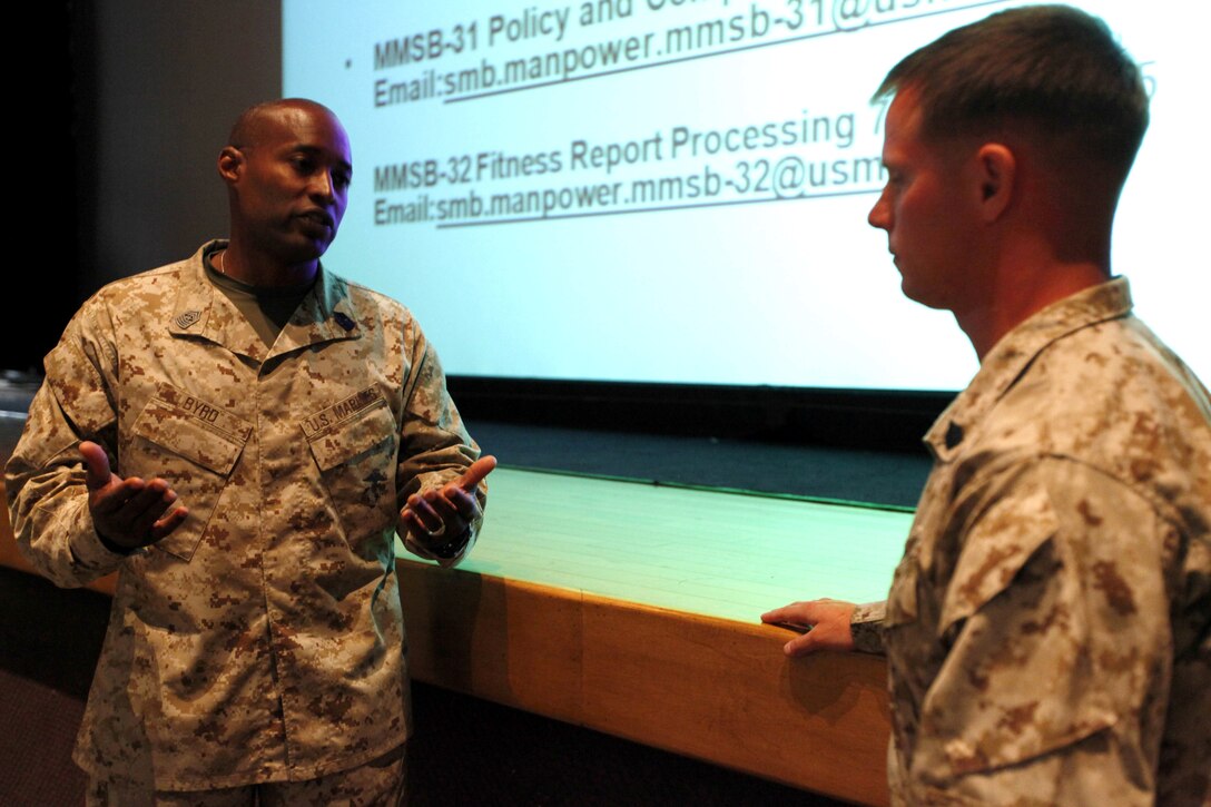 Sgt. Maj. Mark A. Byrd answers a question asked by Sgt. Jasper Sicz after the Manpower Management Support Branch Promotion and Performance brief at the base theater here Aug. 7. The brief covered information to assist Reporting Seniors and Reviewing Officers with completing fitness reports, as well as help Marines receiving reports better understand how they are evaluated. Byrd is the sergeant major for the Performance Evaluation Section at Headquarter Marine Corps. Sicz is a maintenance management chief with 1st Combat Engineer Battalion, 1st Marine Division.