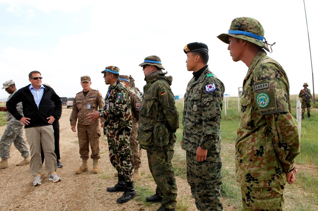 Dr. Peter R. Lavoy, Acting Assistant Secretary of Defense for Asian and Pacific Security Affairs, meets with vehicle checkpoint lane instructors from Nepal, German, Republic of Korea and Japan, during a visit to Five Hills Training Area, Aug.6. Approximately 1,000 service members from 13 different nations are participating in the exercise. The command post exercise (CPX) and field training exercise (FTX) take place at Five Hills Training Area in Mongolia, both focusing on peacekeeping and stability operations. Dr. Lavoy toured the area to meet with exercise participants and leadership from Mongolia, U.S. and other participating nations. U.S. Marine Corps Forces Pacific is the executive agent for Khaan Quest 2013.