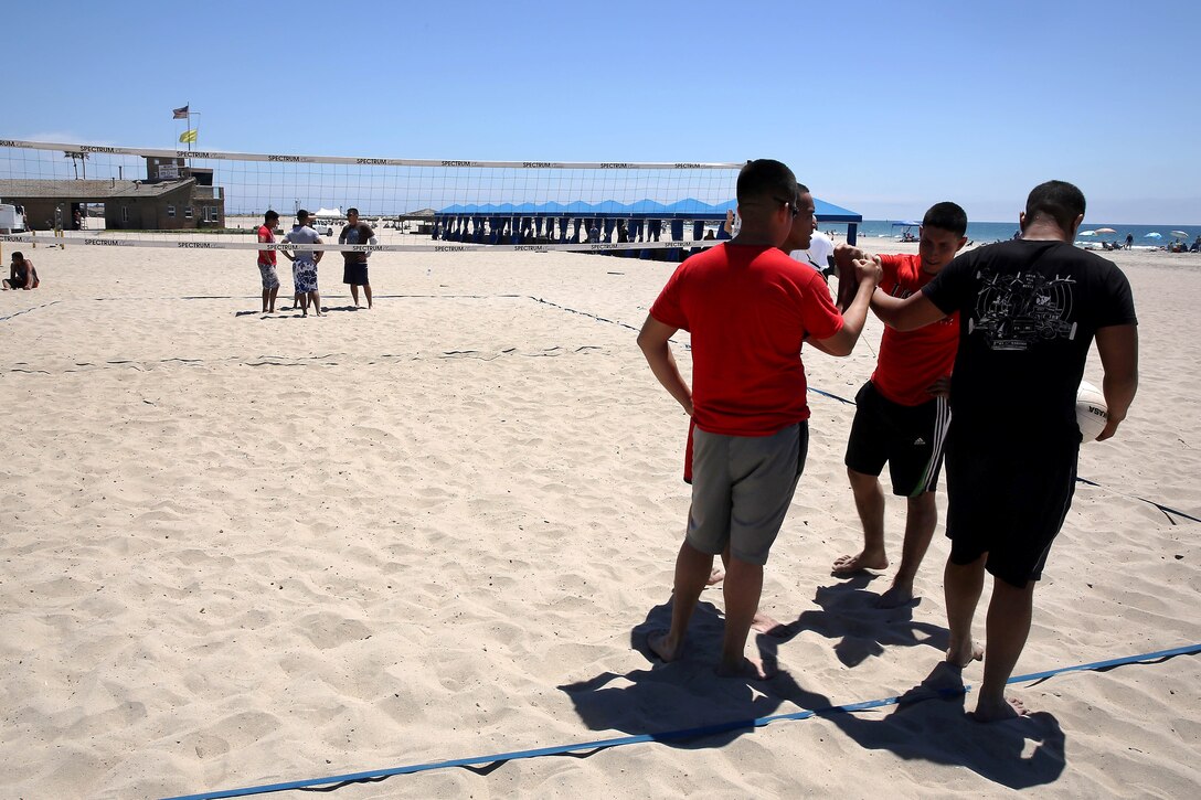 Team USO and the Islanders collaborate during a time out in the final game for the championship title at the Commanding Generals Cup, Four Person Beach Volleyball Tournament held at Del Mar Beach Resort here August 7. The Marines in Team USO are from 1st Light Armored Reconnaissance Battalion here. The Islanders are sailors from the naval hospital here. The tournament is an annual event and had over 120 Marines and sailors in attendance.