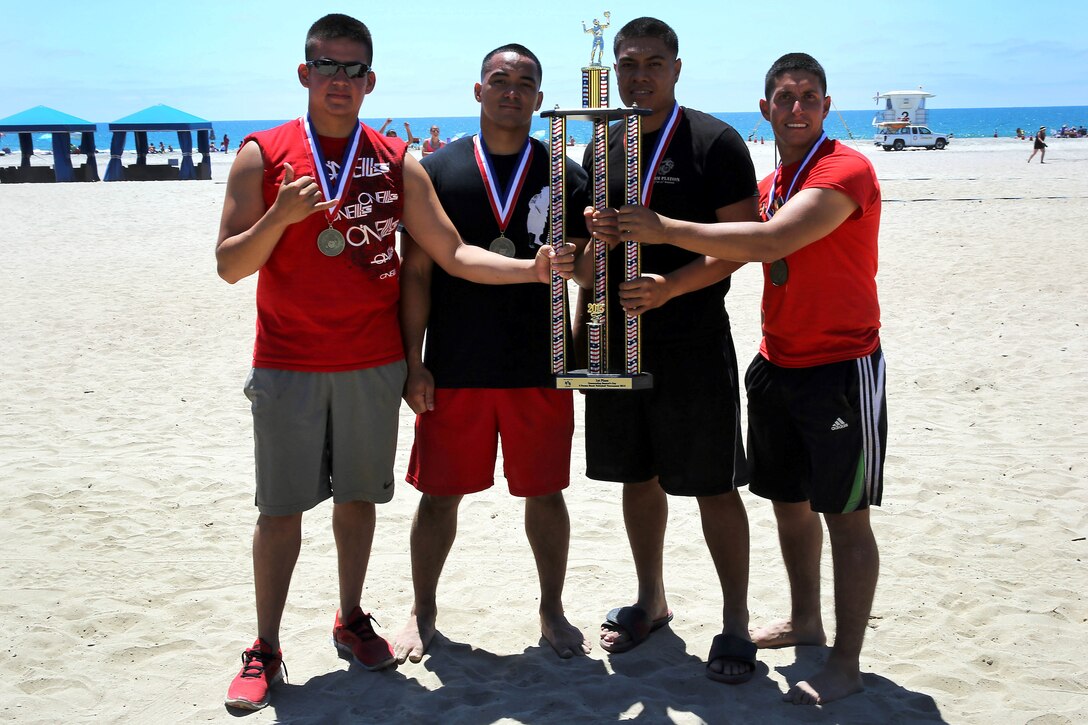 Team USO wears their first place medals and hold their championship trophy after defeating the Naval Hospital Islanders in the title game during the Commanding Generals Cup, 4-Person Beach Volleyball Tournament held at Del Mar Beach Resort here August 7. The Marines in Team USO are from 1st Light Armored Reconnaissance Battalion here. The tournament is an annual event and had over 120 Marines and sailors in attendance.