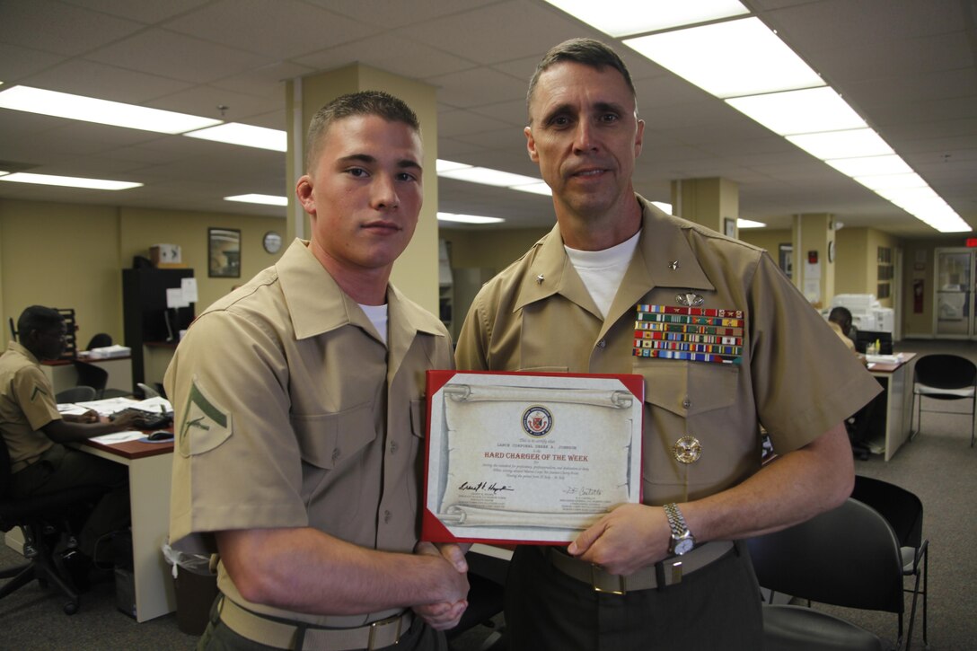 Brig. Gen. Robert F. Castellvi, Marine Corps Installations East commanding general, awards Lance Cpl. Derek Johnson, an administrative specialist with Cherry Point Installation Personnel Administration Center, the Cherry Point Hard Charger of the Week award Aug. 2.



