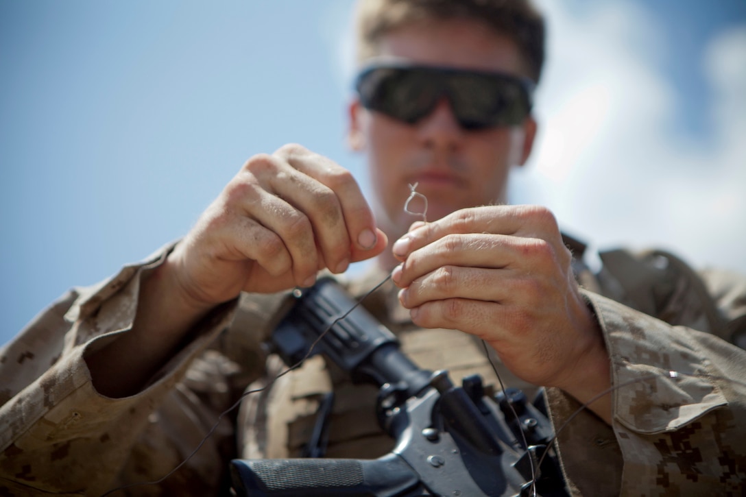 Cpl. Benjamin Brannon, a combat engineer with 2nd Combat Engineer Battalion and a student in the Sapper Leadership Course, connects wires to explosives during rehearsal for a demolition range aboard Marine Corps Base Camp Lejeune, July 22, 2013.  The method of connection, called “Western Union Pigtail Splice,” was one of many ways to prepare a charge the students of the Sapper course learned.