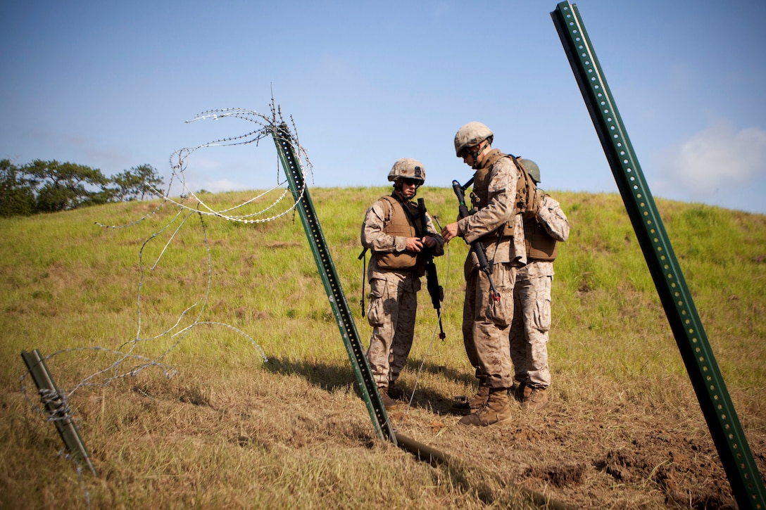 Marines with 2nd and 4th Combat Engineer Battalions and 8th Engineer Support Bn. practice setting up a Bangalore torpedo charge aboard Marine Corps Base Camp Lejeune, July 24, 2013. The Marines used the Bangalore torpedoes to clear paths through wire entanglements by placing several connected tubes of explosives and then taking cover in a bunker during the explosion.  