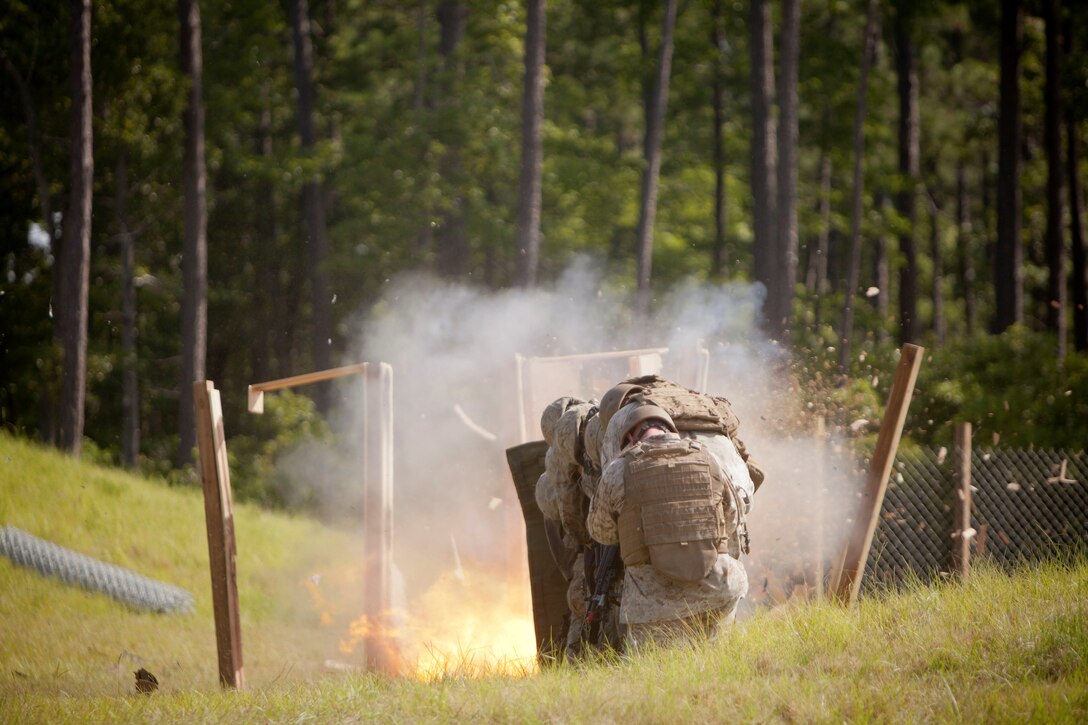 Marines with 2nd and 4th Combat Engineer Battalions and 8th Engineer Support Bn. stand by during a breaching explosion aboard Marine Corps Base Camp Lejeune, July 24, 2013. The urban demolition range was part of the Sapper Leaders Course, the first of its kind designed to allow Reserve Marines to participate with active-duty Marines to receive advanced training in the combat engineer military occupational specialty.
