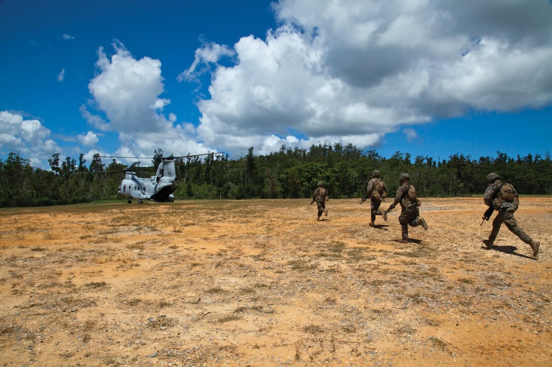 Marines run toward a CH-46E Sea Knight helicopter July 30 at Landing Zone Falcon in the Central Training Area during insertion-and-extraction training. The Marines inserted into the landing zone to achieve the time-sensitive task of gathering intelligence before an emergency evacuation. The Marines are with 3rd Battalion, 3rd Marine Regiment, currently assigned to 4th Marine Regiment, 3rd Marine Division, III Marine Expeditionary Force, under the unit deployment program. The helicopter and aircrew are with Marine Medium Helicopter Squadron 262, Marine Aircraft Group 36, 1st Marine Aircraft Wing, III MEF. 