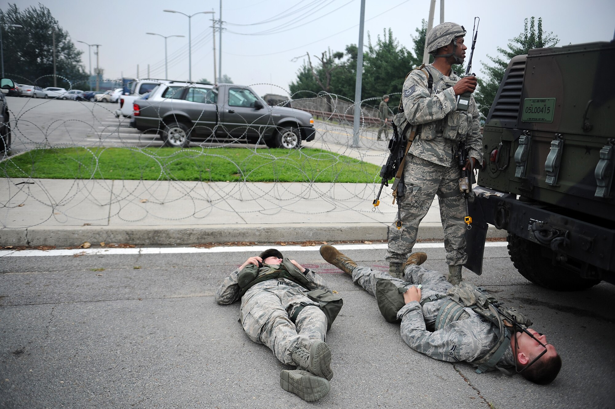 Tech Sgt. Maurice Butler, 51st Security Forces defender, watches over bodies of opposing forces members after 51st SFS members simulated killing them during the last counter surveillance scenario during an operation readiness exercise, Beverly Midnight 13-03 at Osan Air Base, Republic of Korea, Aug. 9, 2013. Exercises like BM 13-03 tests Osan Airmen’s abilities during a heightened state of readiness while providing combat ready forces for close air support, air strike control, counter air, interdiction, theater airlift, and communications in the defense of the Republic of Korea. (U.S. Air Force photo/Staff Sgt. Sara Csurilla)