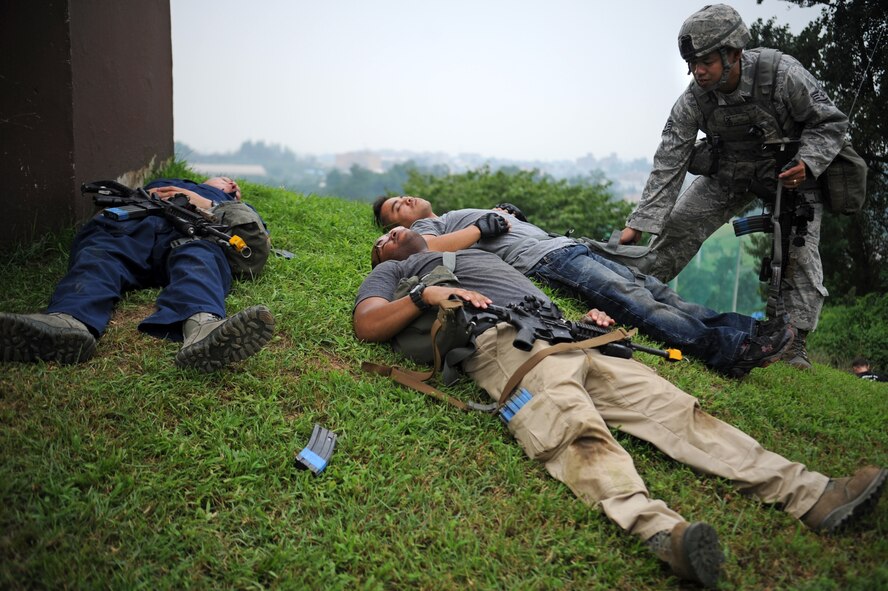 Staff Sgt. Winston Cuison, 51st Security Forces Squadron defender, checks the bodies of opposing forces members after 51st SFS members simulated killing them during the last counter surveillance scenario during Operational Readiness Exercise Beverly Midnight 13-03 at Osan Air Base, Republic of Korea, Aug. 9, 2013. Counter surveillance scenarios are conducted throughout the ORE in order to help security forces Airmen learn how to better secure the base and defend against opposing forces. (U.S. Air Force photo/Staff Sgt. Sara Csurilla)