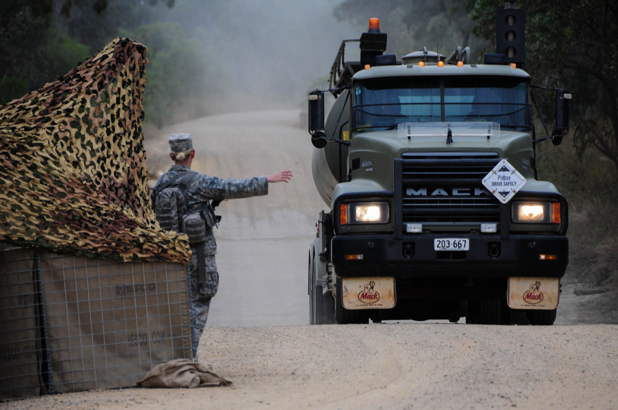 Senior Airman Hannah Phillips, 736th Security Forces Squadron response force leader, halts a vehicle at an entry control point July 22, 2013, at Royal Australian Air Force Williamson Airfield, Australia during Talisman Saber. The 36th Contingency Response Group, from Andersen Air Force Base, Guam, participated in the two-week exercise where their mission included initial air base opening operations after a simulated seizure of an airfield from enemy forces to support the surge of more coalition forces.  (U.S. Air Force photo by Airman 1st Class Marianique Santos/Released)